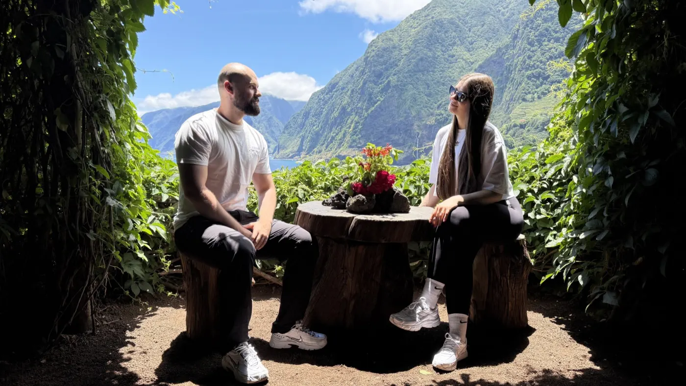 Cristi and Diana at a table above the green mountains of Madeira